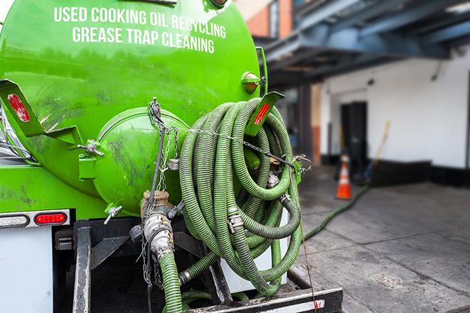 a technician pumping a grease trap in a commercial building in Vandalia